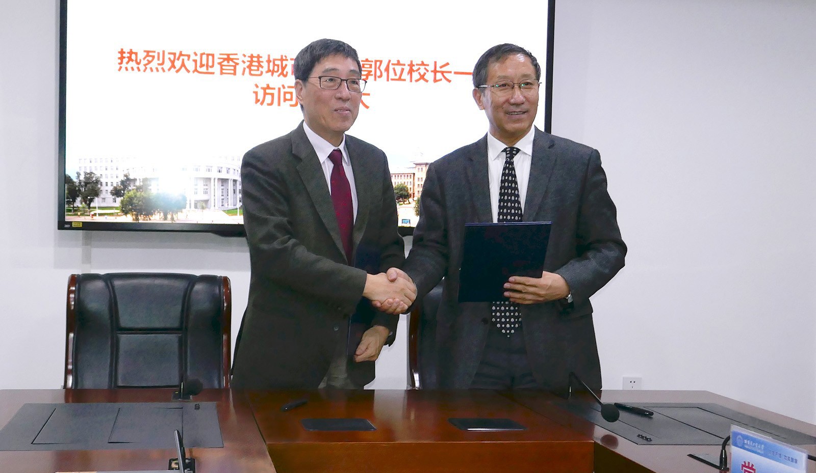 Professor Kuo (left) and Professor Zhou sign the MOU.
