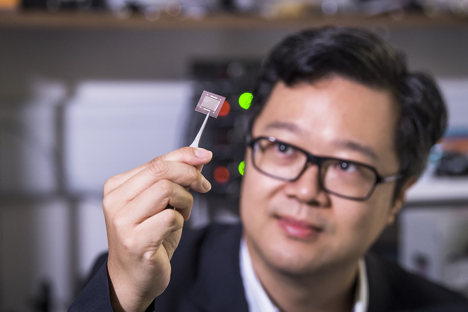 Professor Ho looks at a chip implanted with his new superlattice nanowires. 