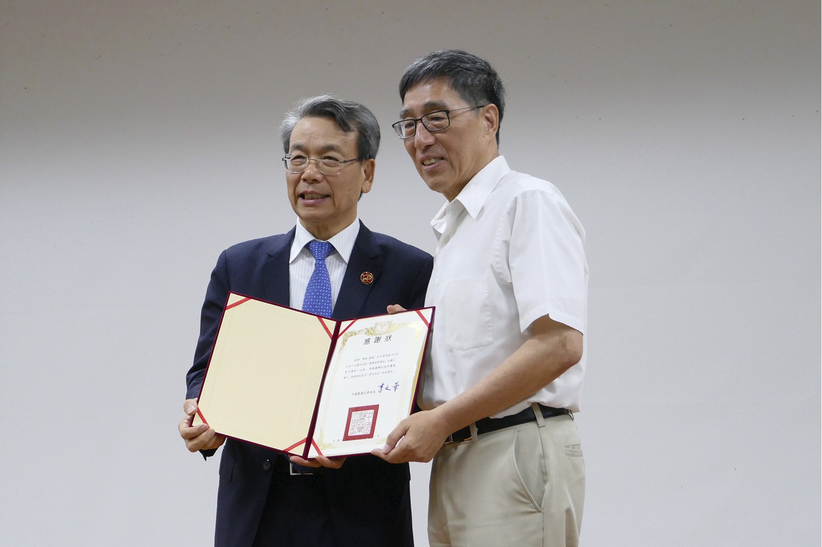 Professor Kuo (right) receives a certificate of appreciation from Professor Lee Wen-hwa, President of CMU.