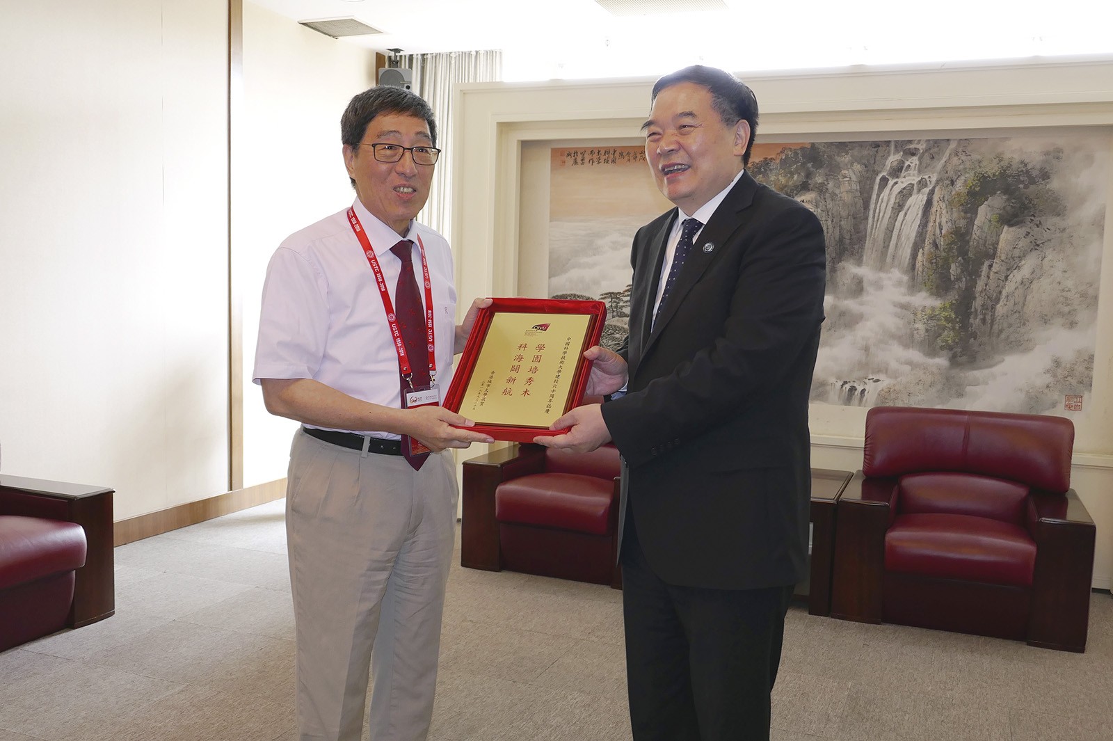 Professor Kuo (left) presents a souvenir to Professor Bao Xinhe, President of USTC.